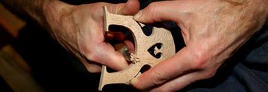A picture a a violin bridge being repaired